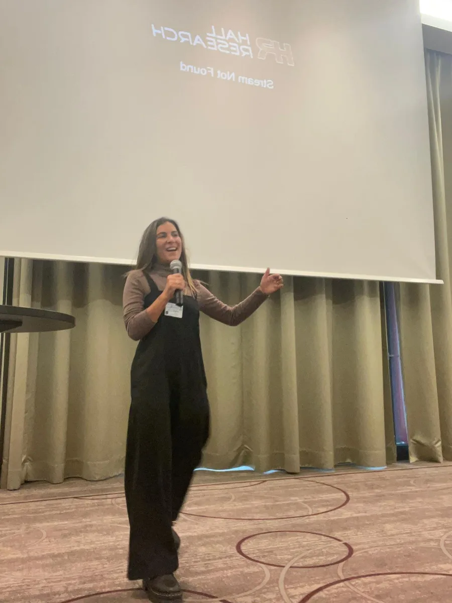 Raz speaking on stage at a conference